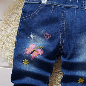 Macacão Jardineira Jeans  c/ Aplicações Pompom Bebê Menina | 9 Meses - 4 Anos